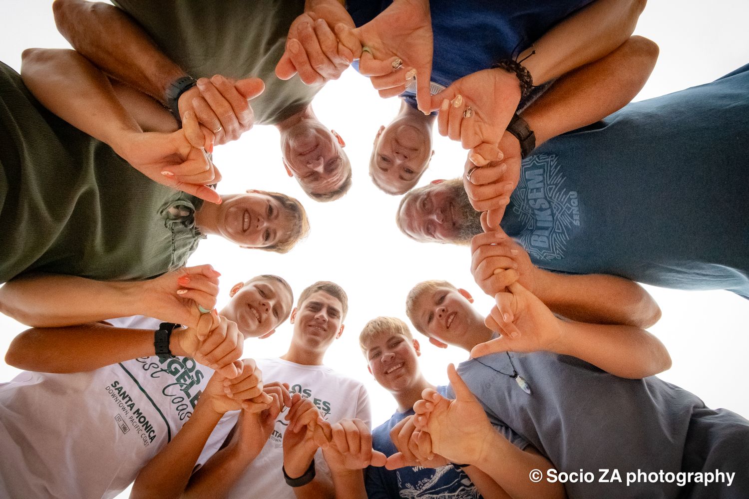 Creative group photoshoot in Jeffrey's Bay — overhead shot of family or group hands forming a circle, by Socio ZA Photography, Eastern Cape