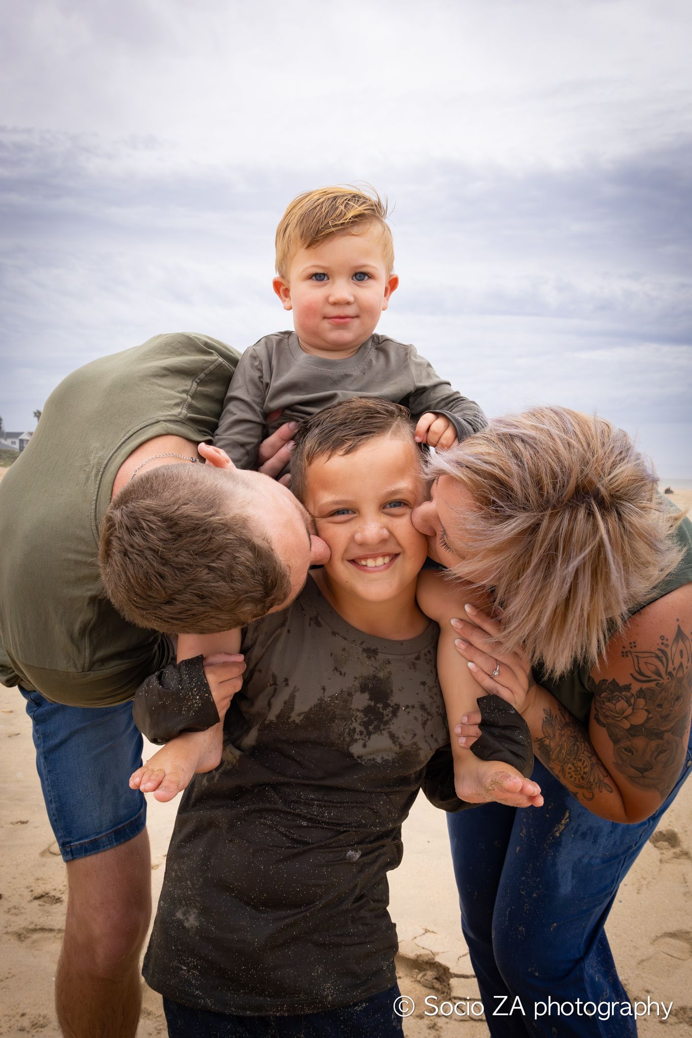 Candid family beach photoshoot in Jeffrey's Bay — joyful moment of parents and child running along the shoreline.