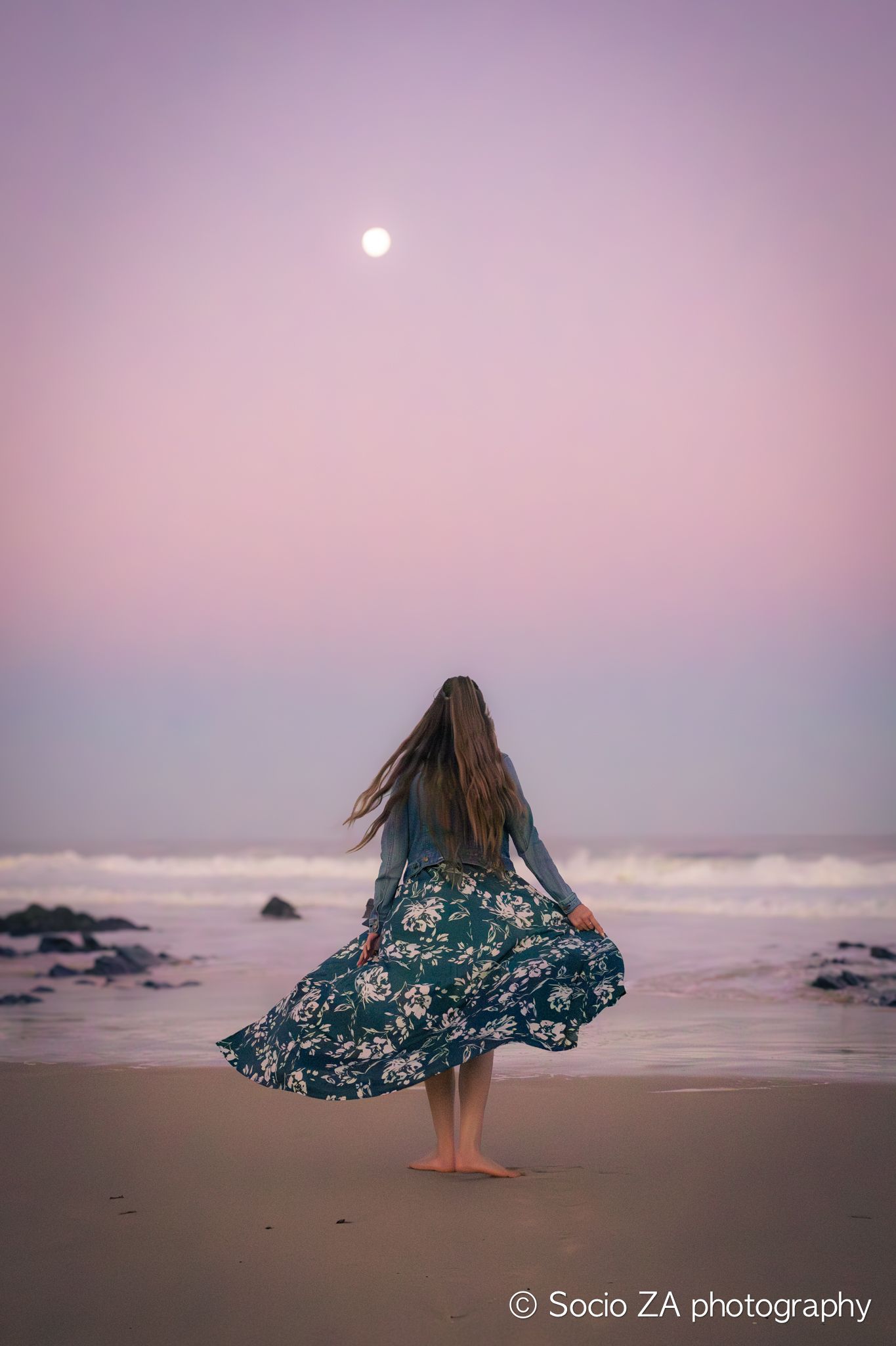 Woman dancing under the full moon on the beach in Jeffreys Bay Eastern Cape. Portrait.