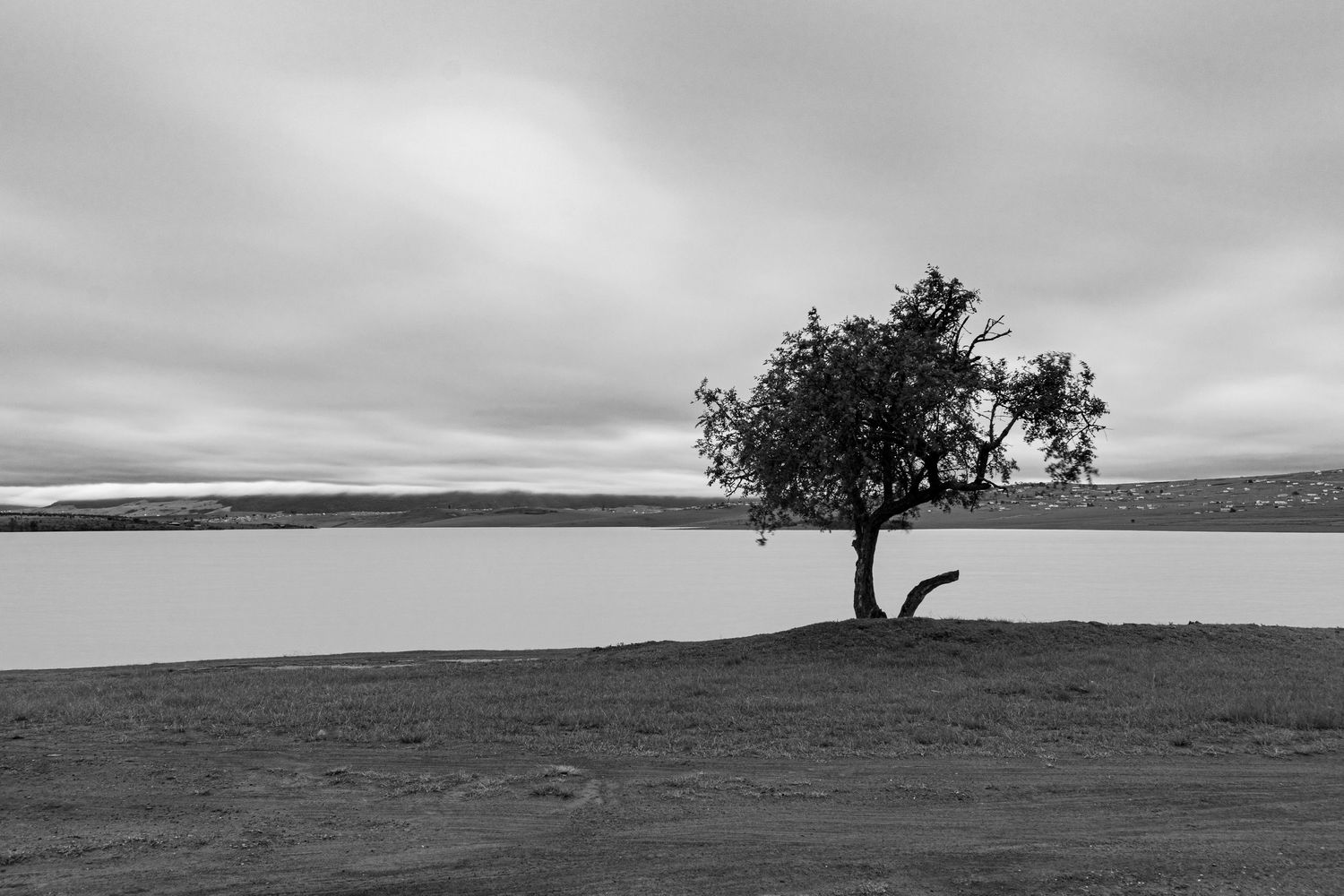 Black and white landscape image taken at Mthatha Dam during sunset.