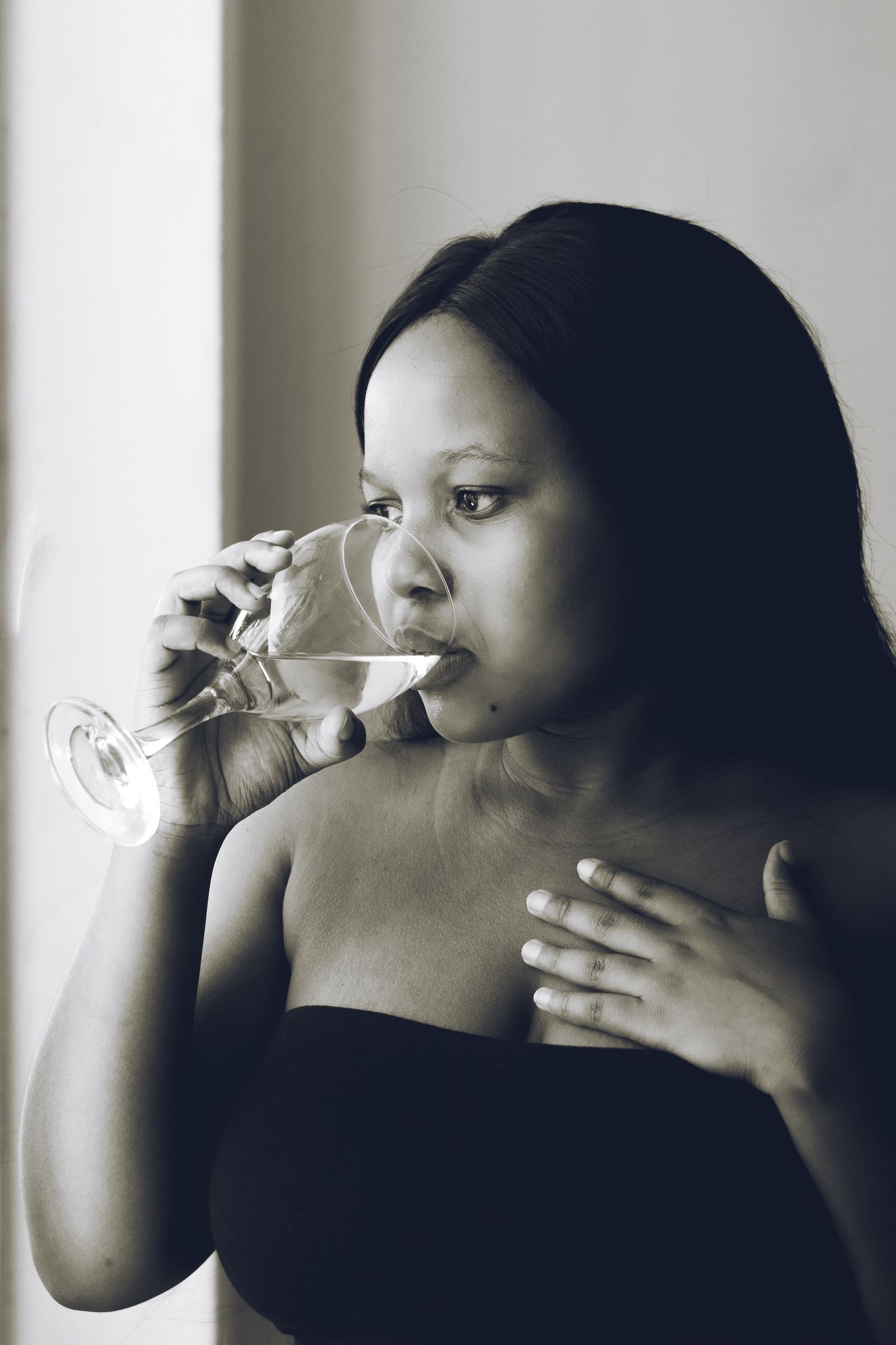 Woman drinking wine looking outside the window in Durban.