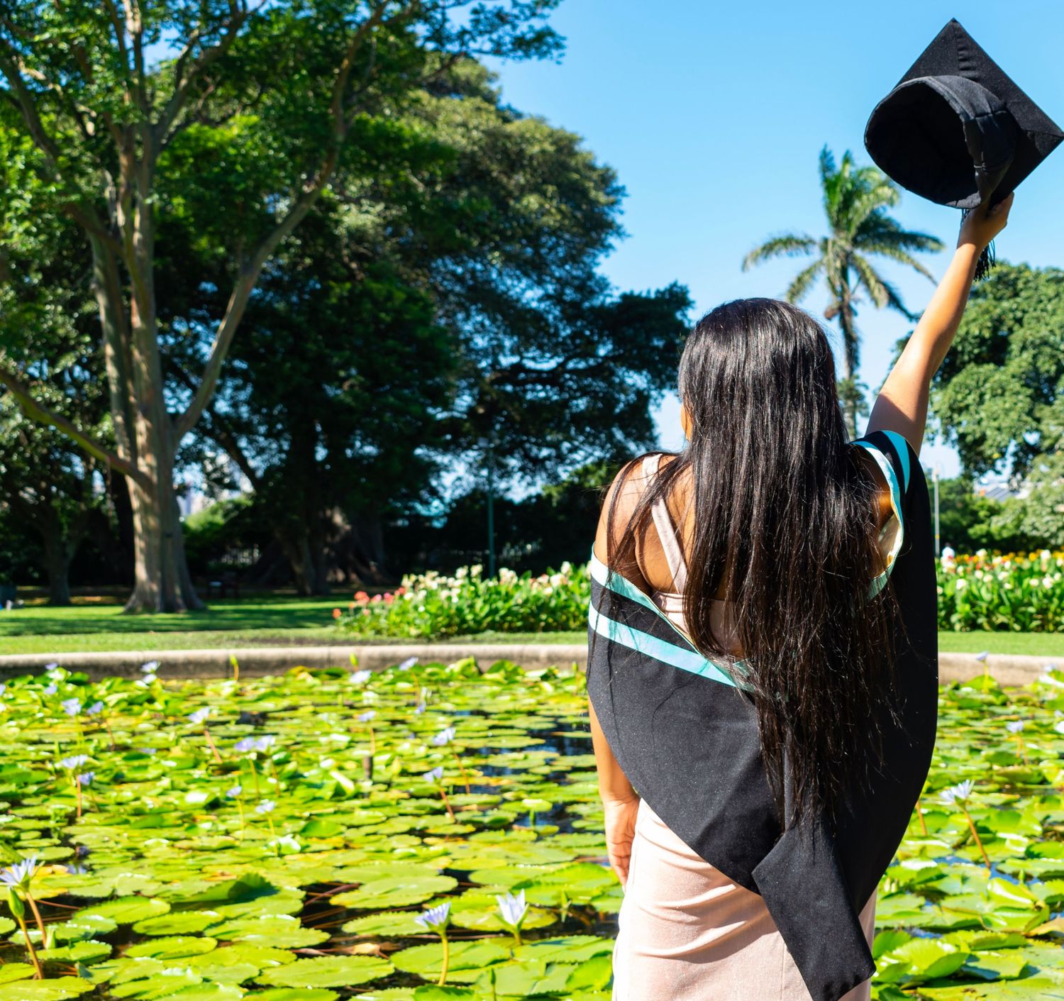 A woman waves her graduation cap during a graduation photoshoot held in Durban.