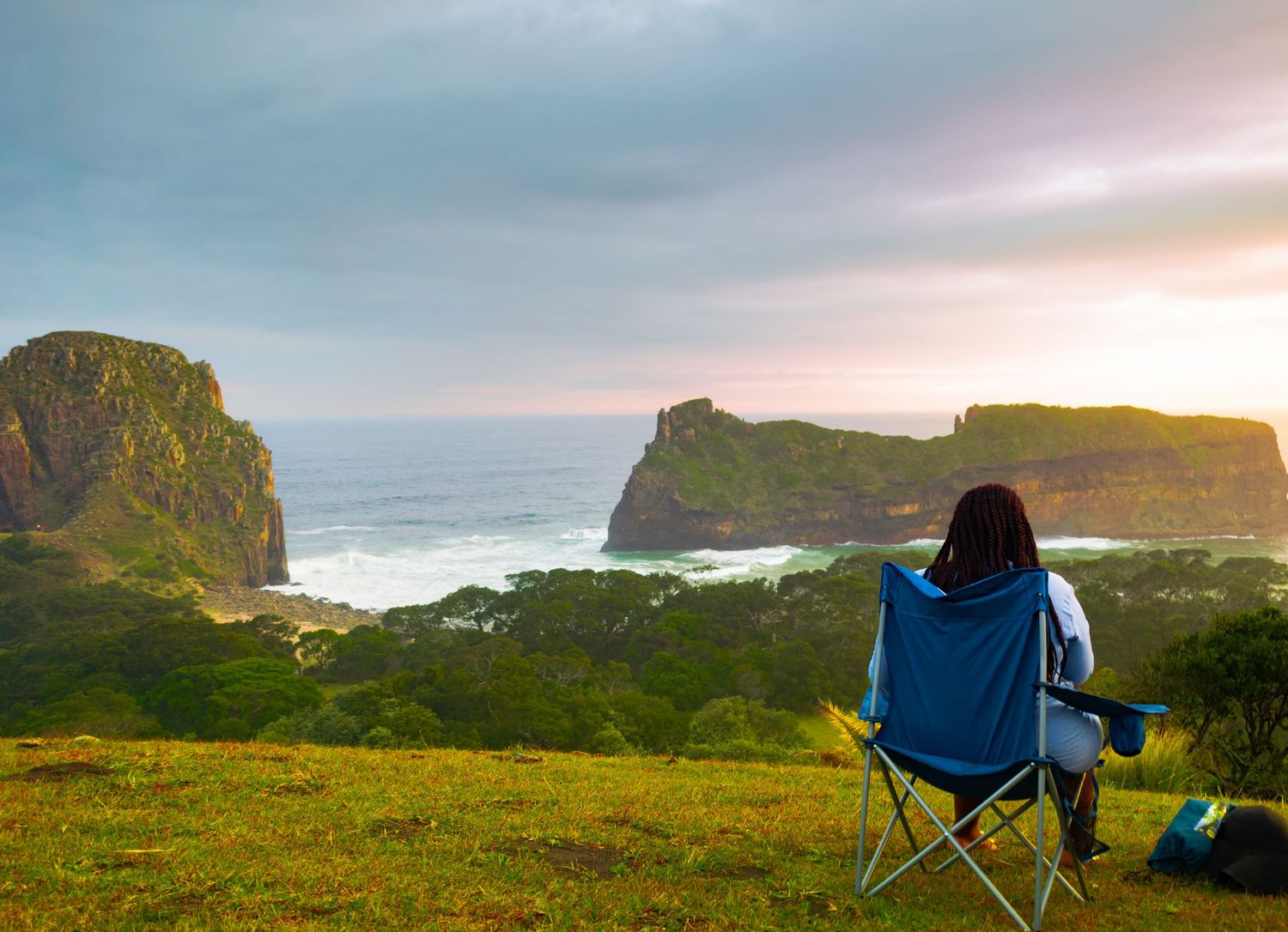 A woman sitting and watching the view on top a hill in Hole in The Wall, Coffee Bay.