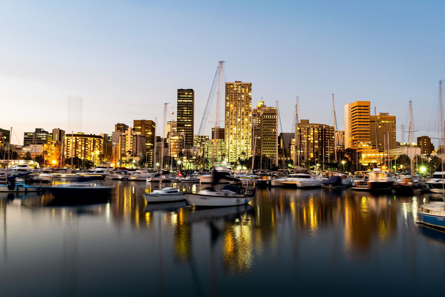 Durban Harbour image consisting of boats and buildings just after sunset