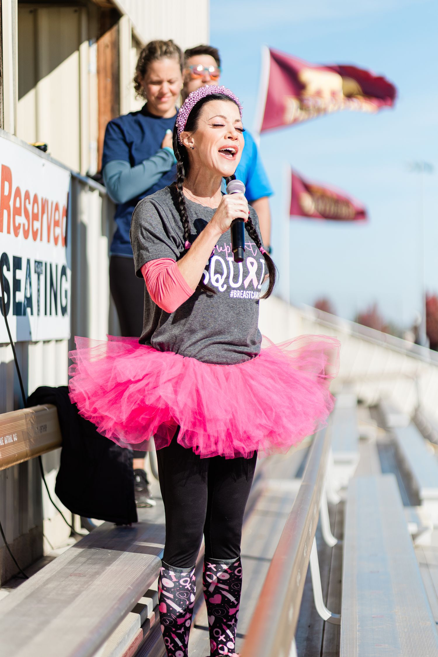 A woman wearing a pink tutu singing the national anthem at a race in Bend Oregon