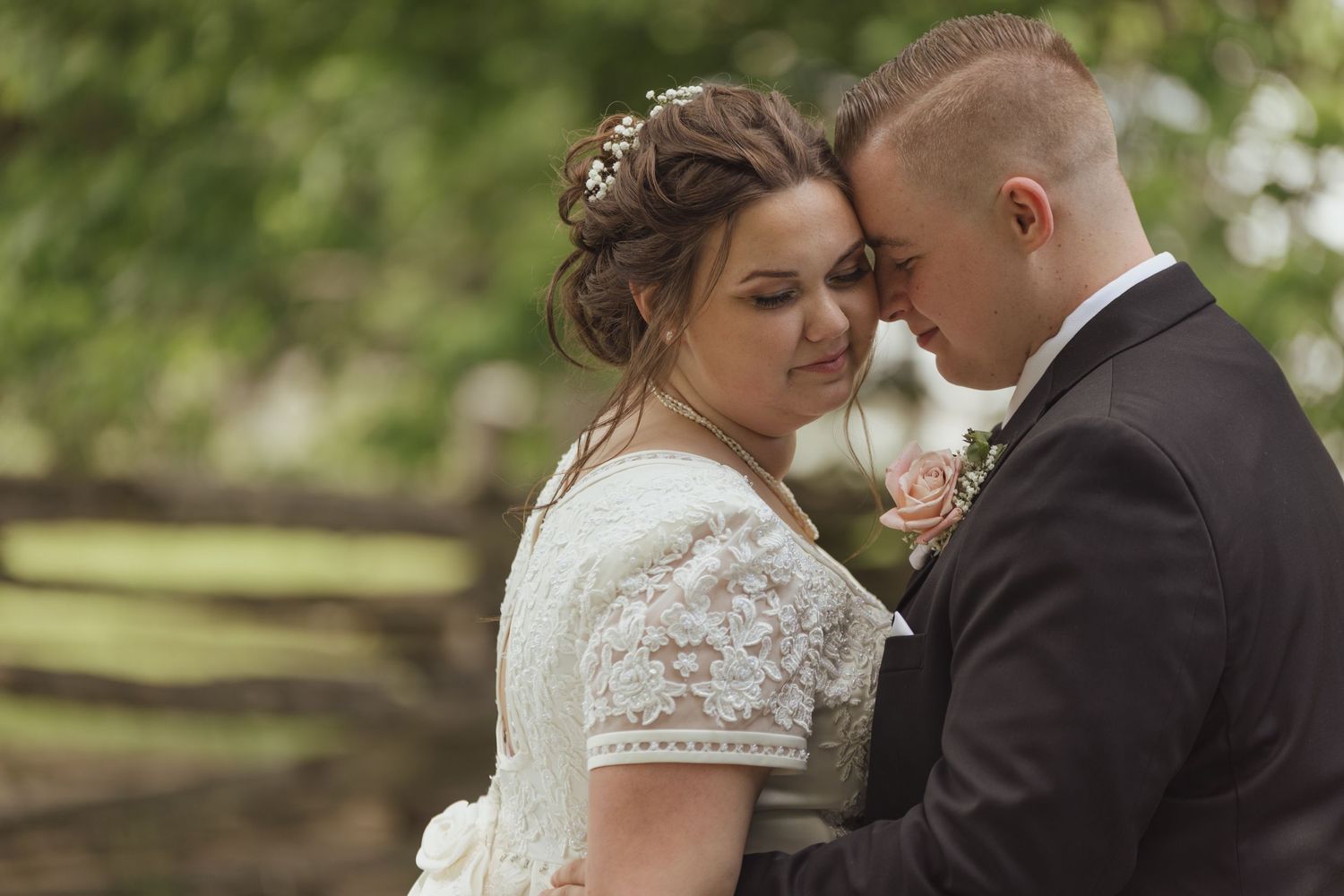 Intimate wedding couple portrait in lush garden setting.