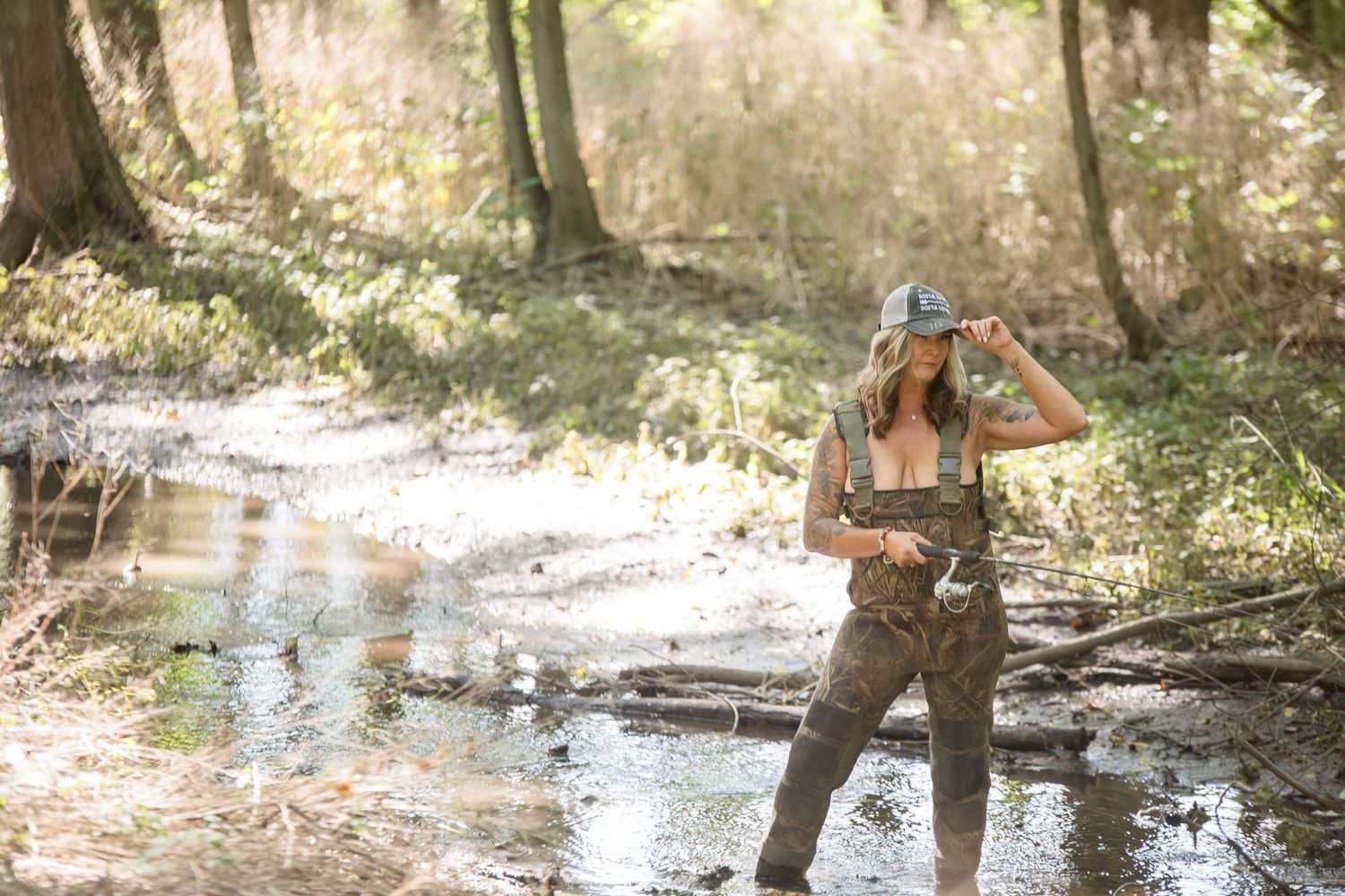 Group of friends walking through a misty creek in natural outdoor setting.