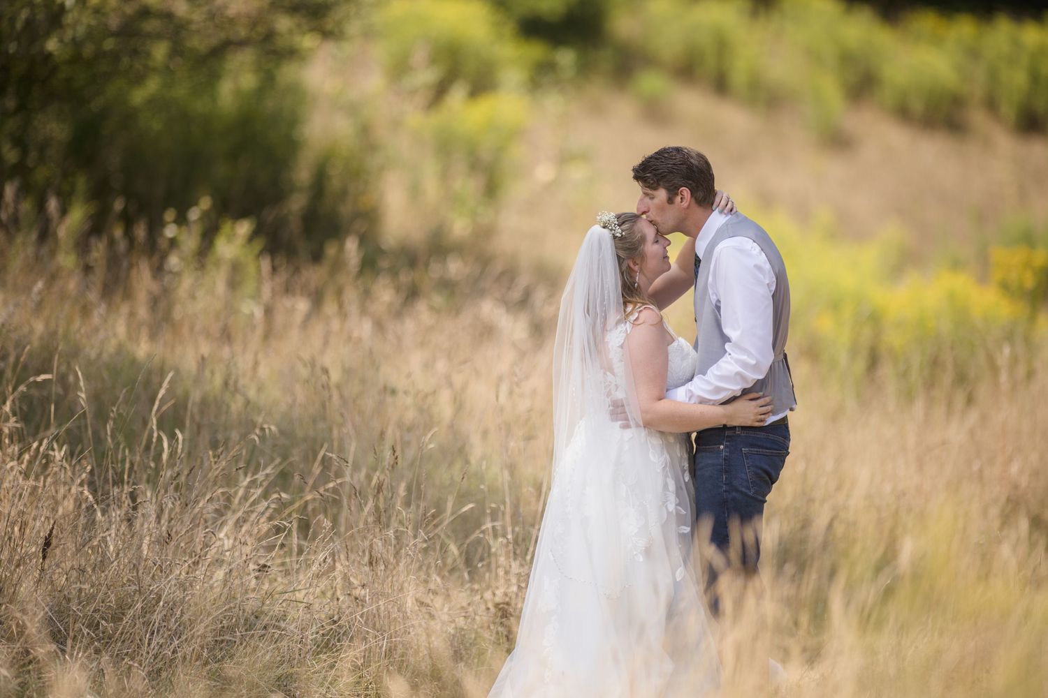 Couple shares romantic moments in golden field during sunset.