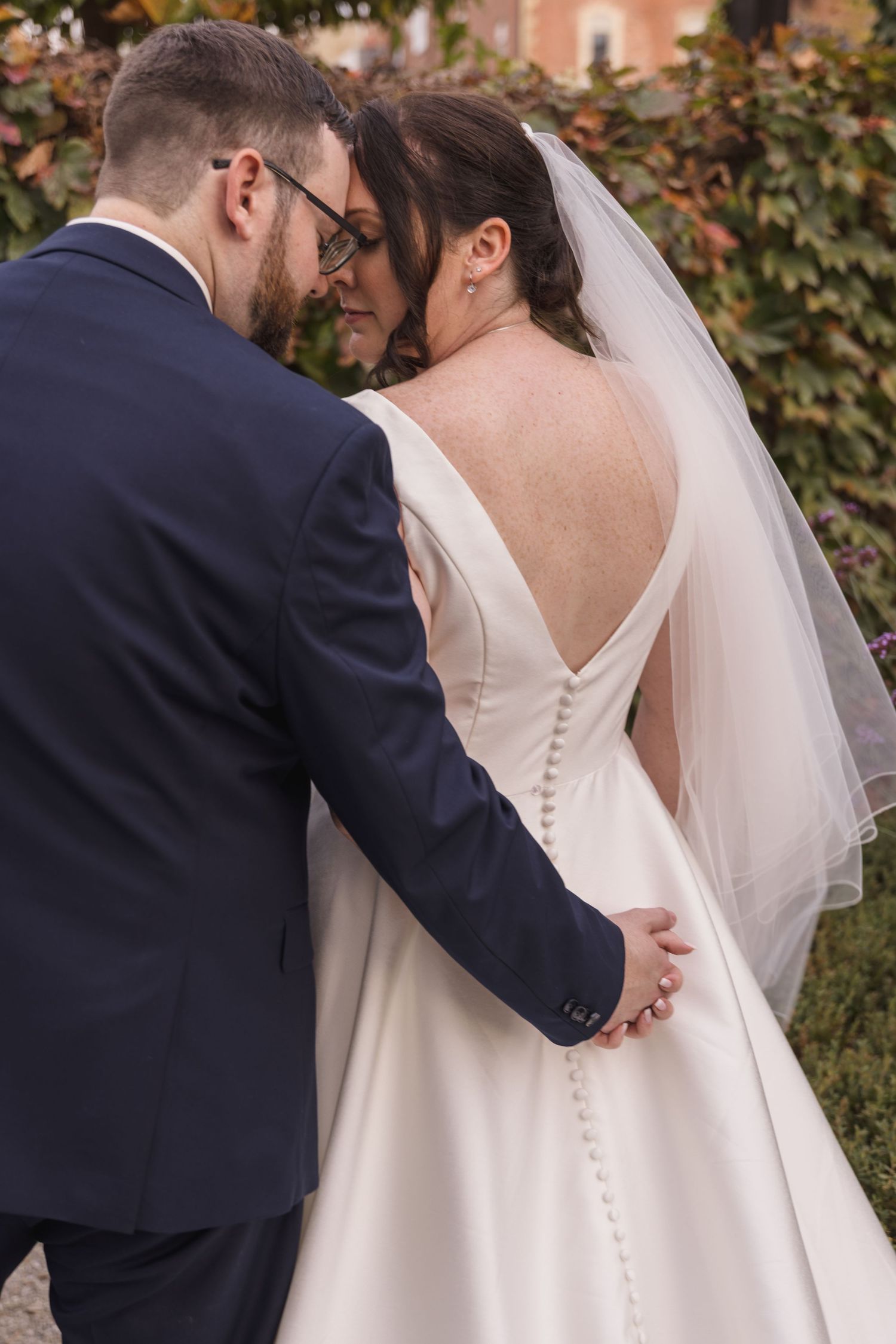 Close-up details of a white wedding dress with delicate button closures down the back.