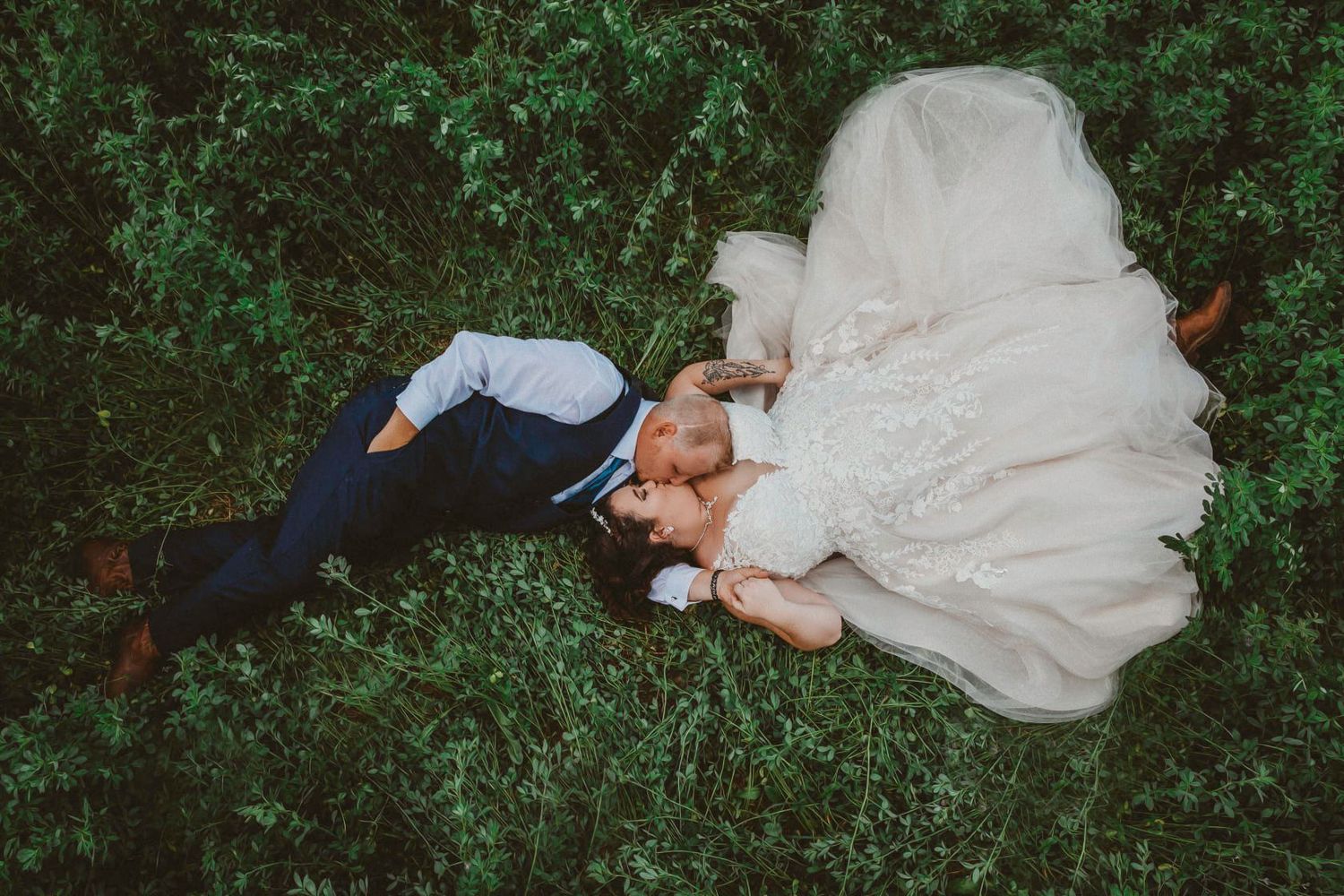 Artistic series showing a figure in white dress lying among green foliage.