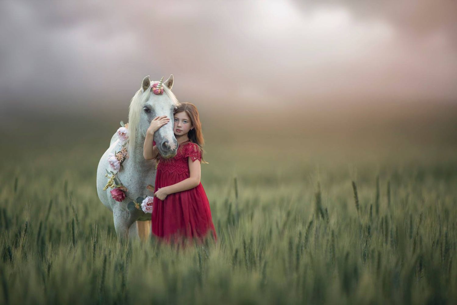 Whimsical photoshoot in a wheat field featuring flowing dresses and soft lighting.