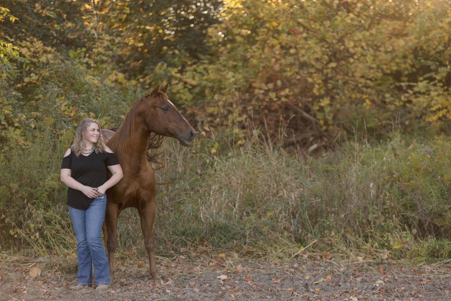 Equestrian photography session in a natural woodland setting during fall.