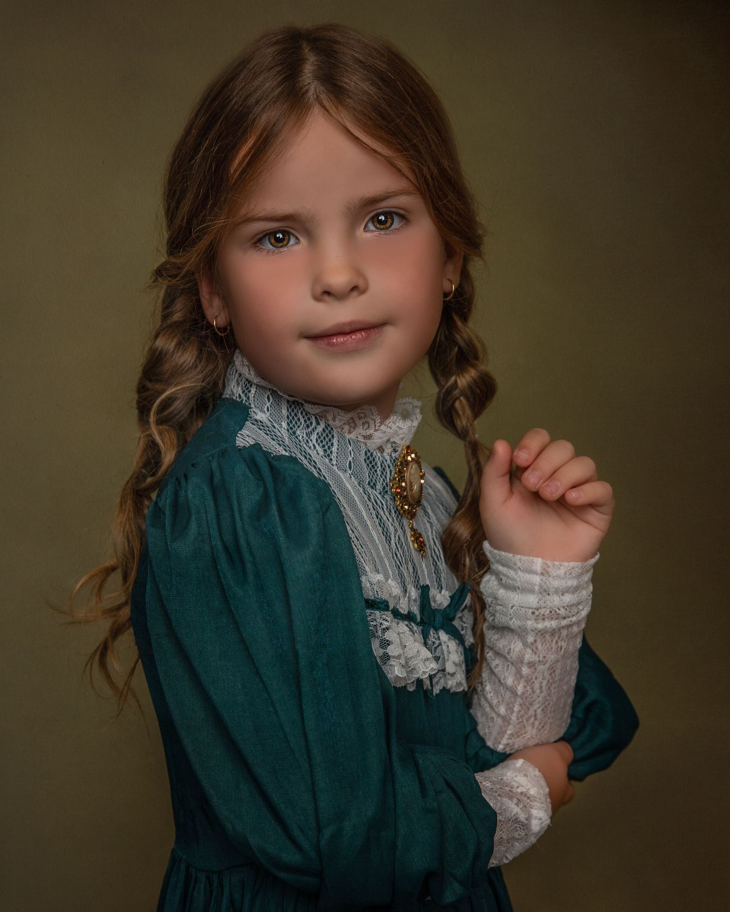 Portrait in a vintage emerald dress with white lace details and braided hair.