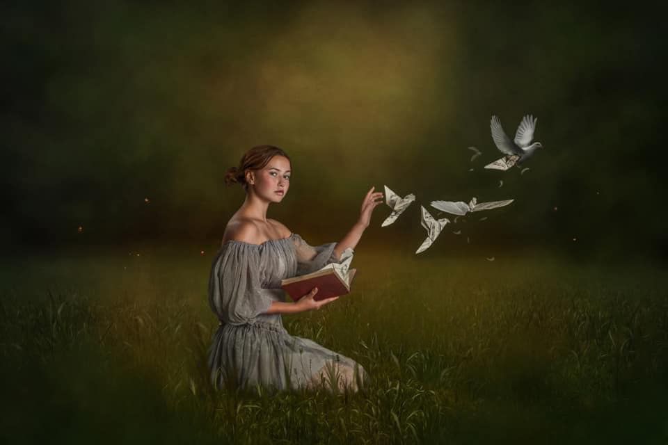Whimsical scene of white doves flying around a figure in a meadow at dusk.