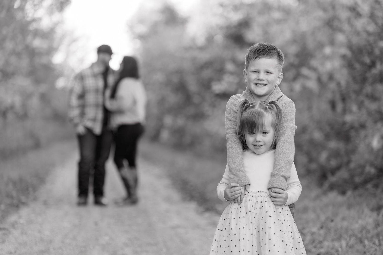 Children playing and smiling in a garden path setting.