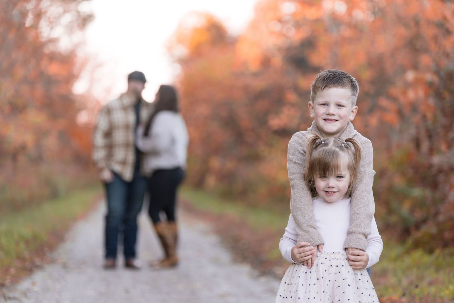 Candid family moments captured during fall photo session on rustic path.