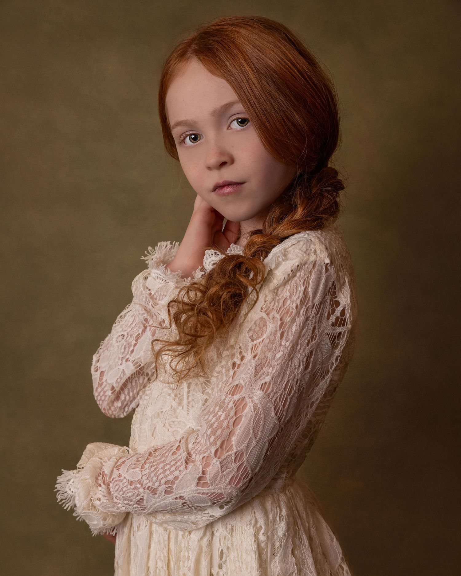 Fine art portrait in vintage style featuring a lace dress and long braided hair against a dark background.