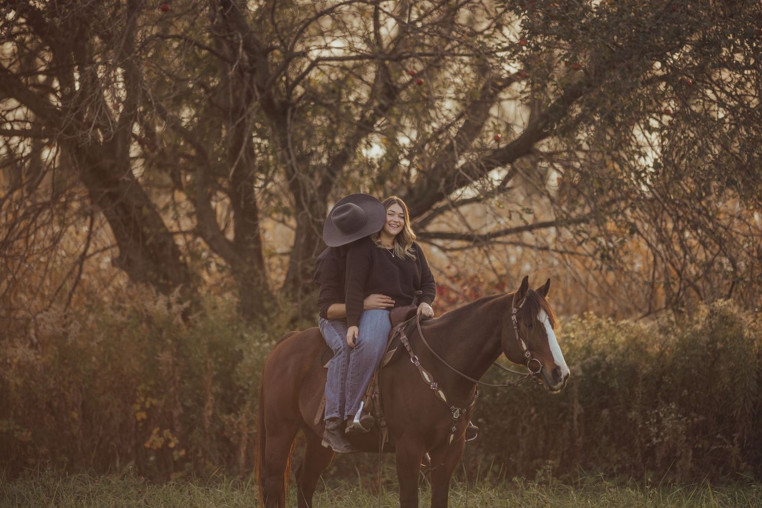 Horse and people walking together through an autumn landscape at sunset.