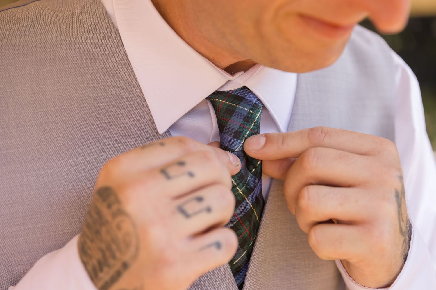 Detail shots of hands adjusting formal wedding attire and accessories.