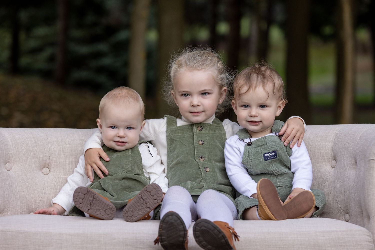 Family and dog sitting together on a wooden bench during a fall photo session.