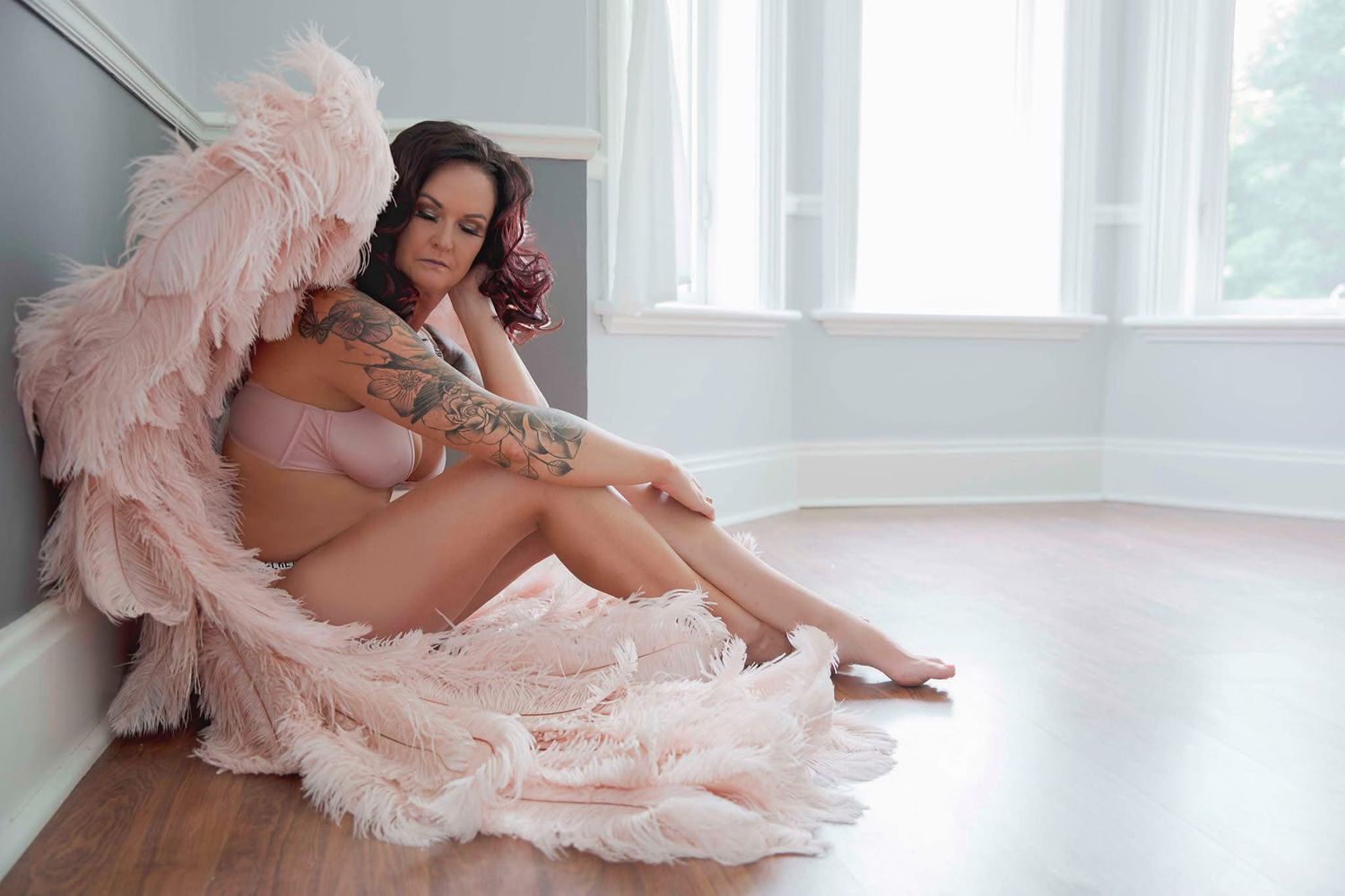 Elegant boudoir session with flowing pink tulle in bright natural window light.