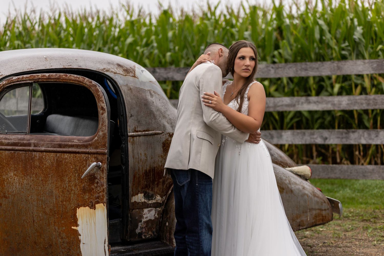 Wedding photos featuring a couple posing with a vintage rustic truck in a countryside setting.