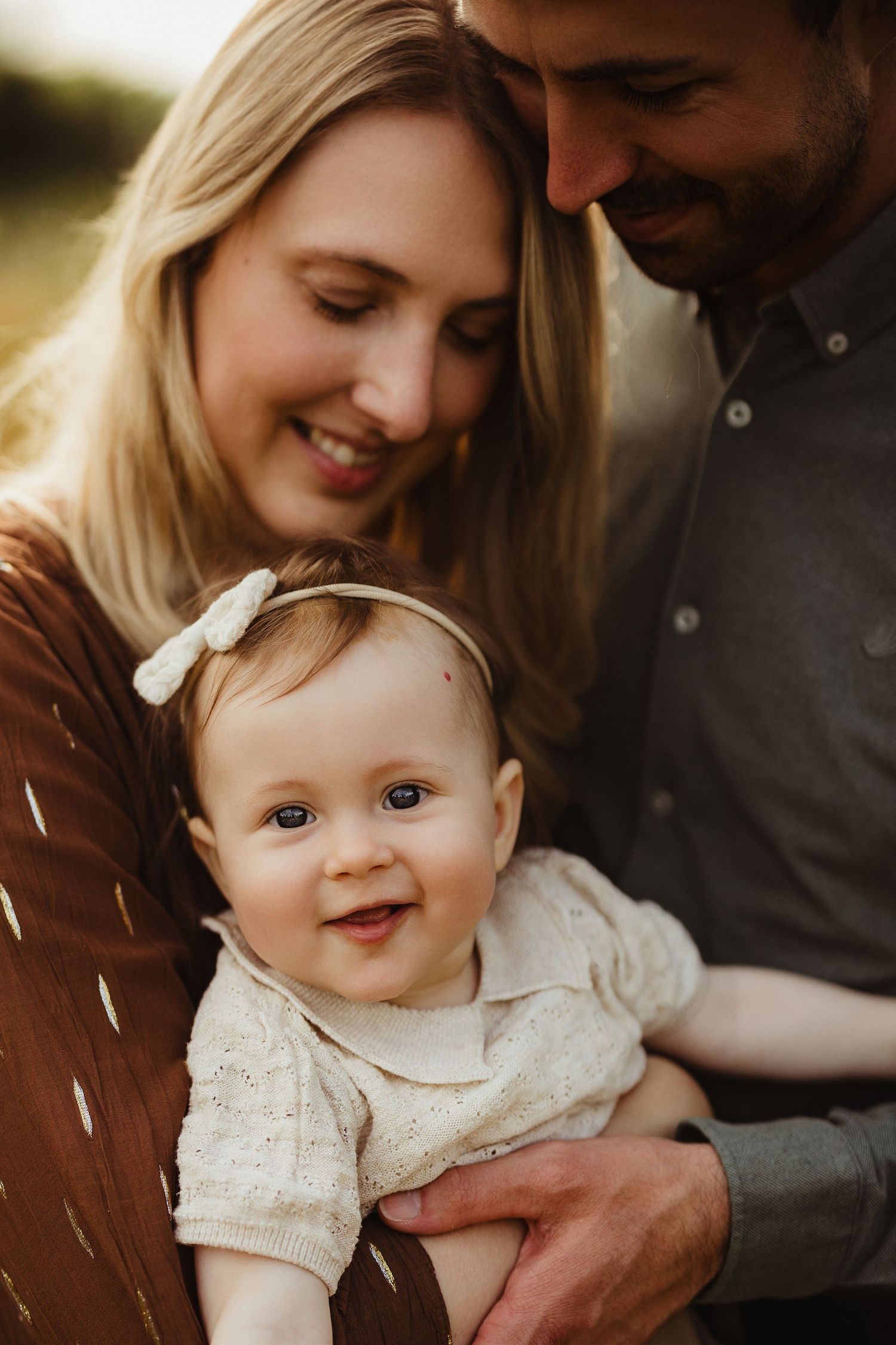 Close-up portraits of a baby wearing a white lace dress with a bow headband.