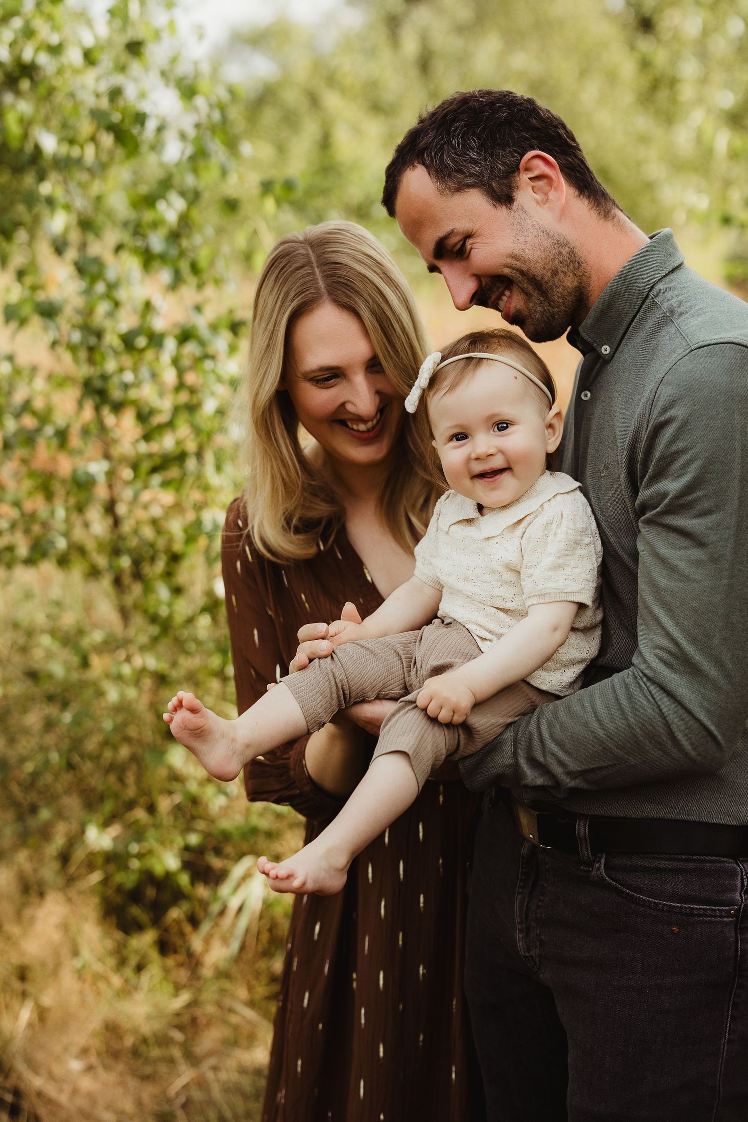 Joyful family moment captured against lush green foliage background.