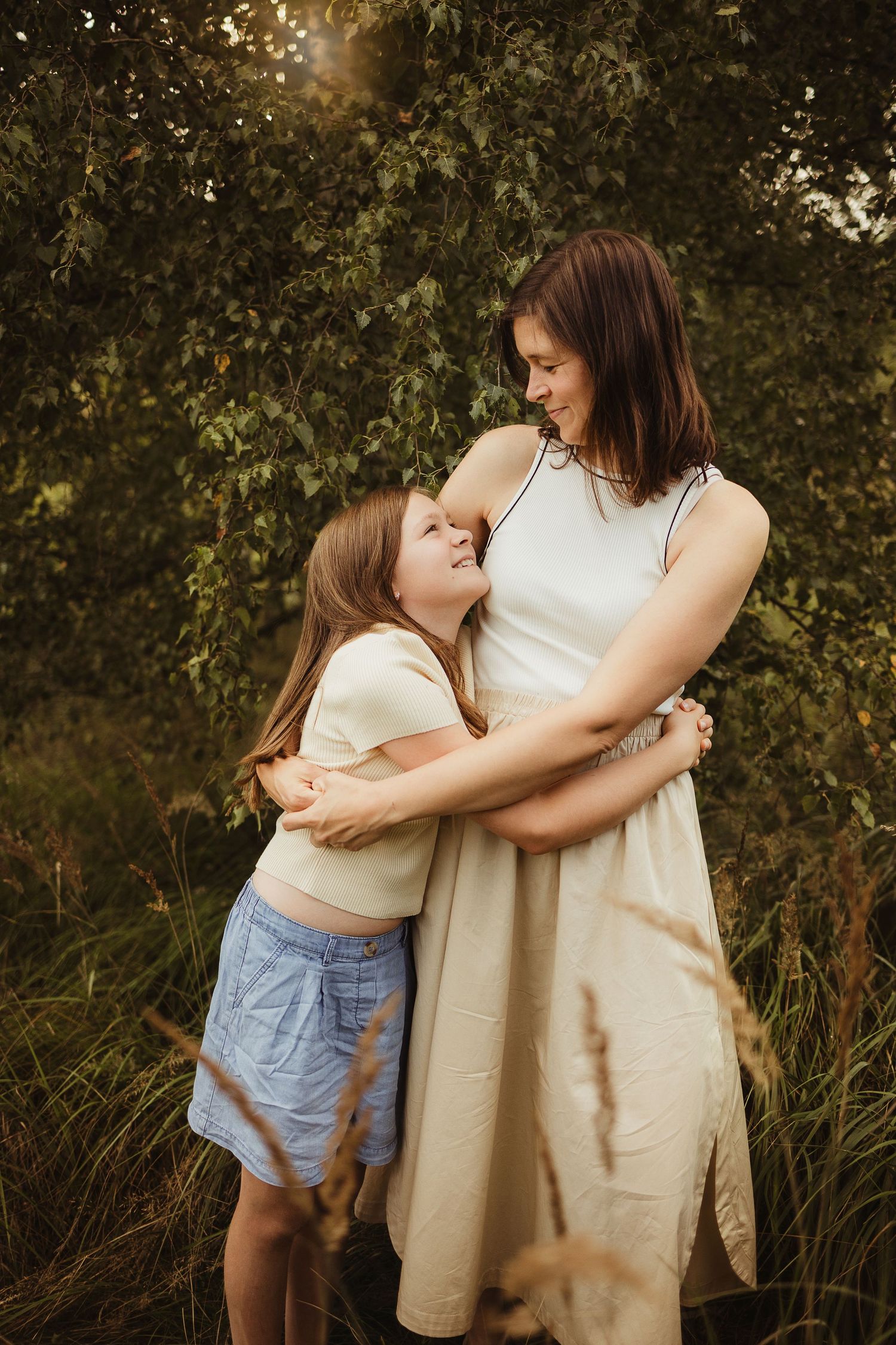 Mother and child sharing tender embraces against a natural backdrop at sunset.