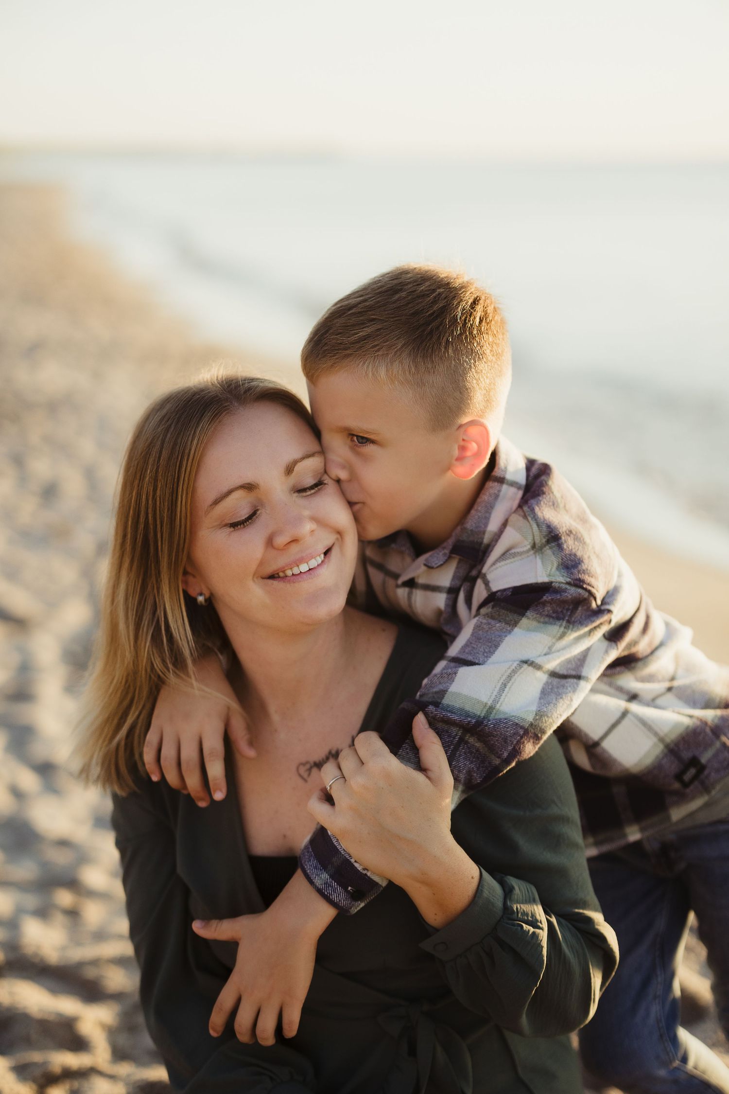 Tender moment between parent and child sharing affectionate embrace on sunny beach.