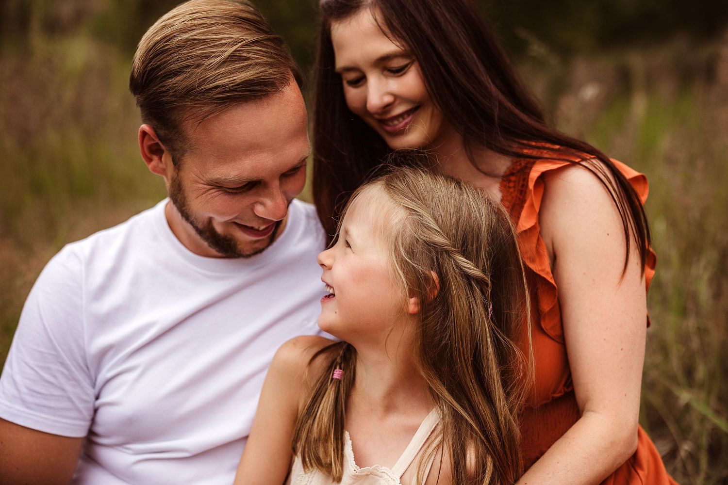 Tender family moment captured in a natural outdoor setting with warm lighting.