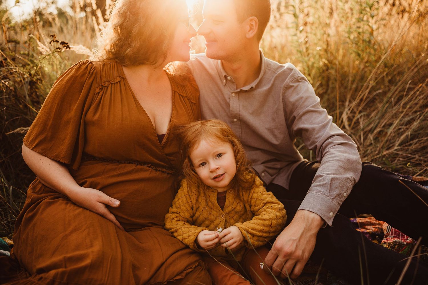 Golden hour family photography session in a sun-lit field.