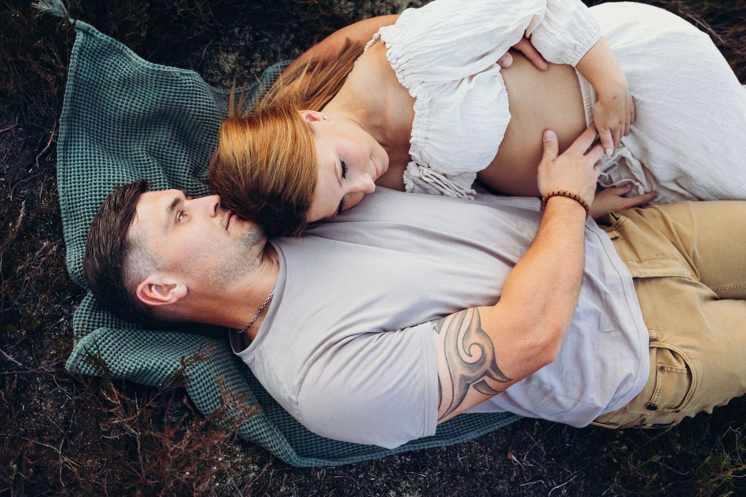 Intimate family lifestyle photography session on a cozy blanket outdoors.