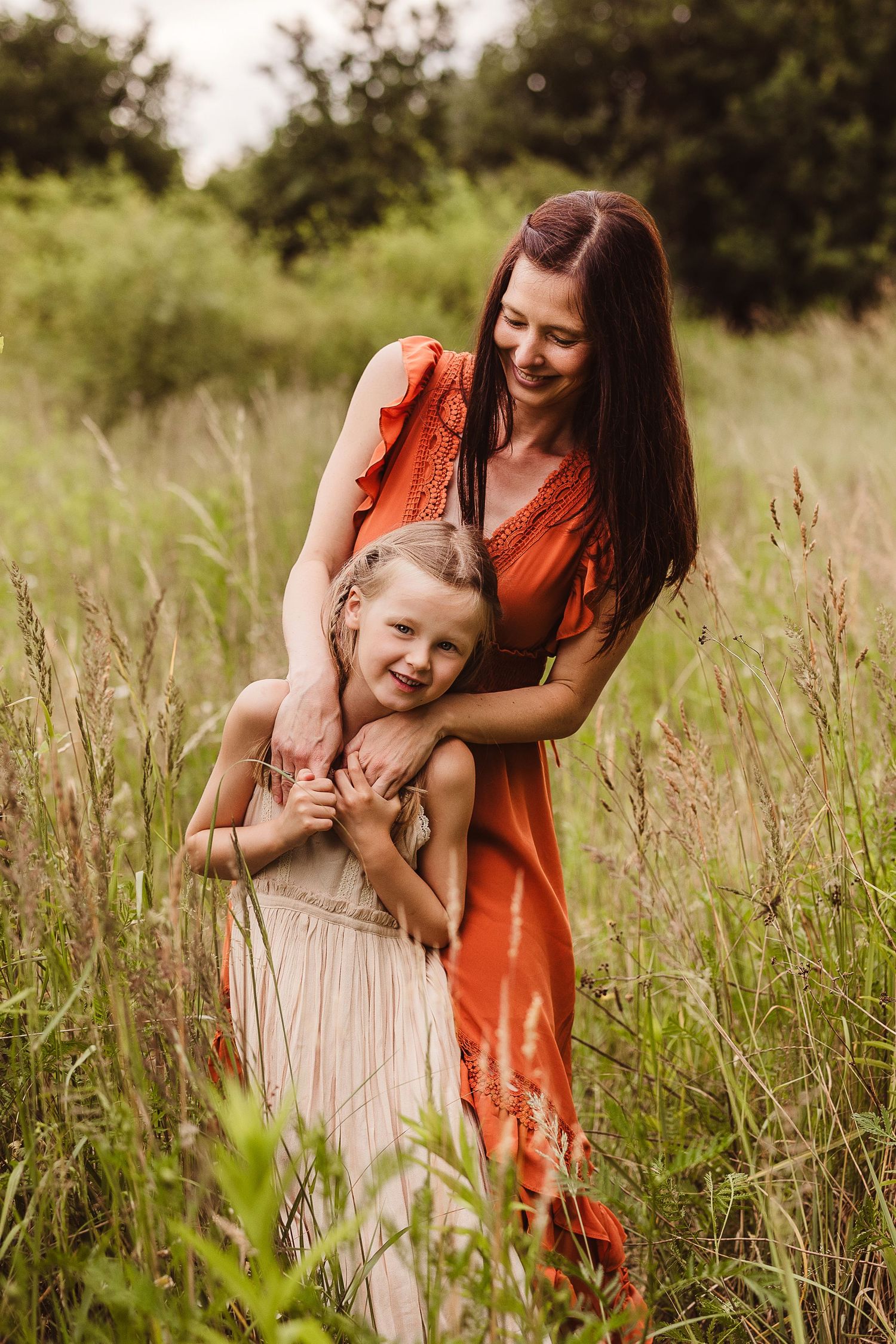 Mother and daughter sharing playful moments in a wildflower field.