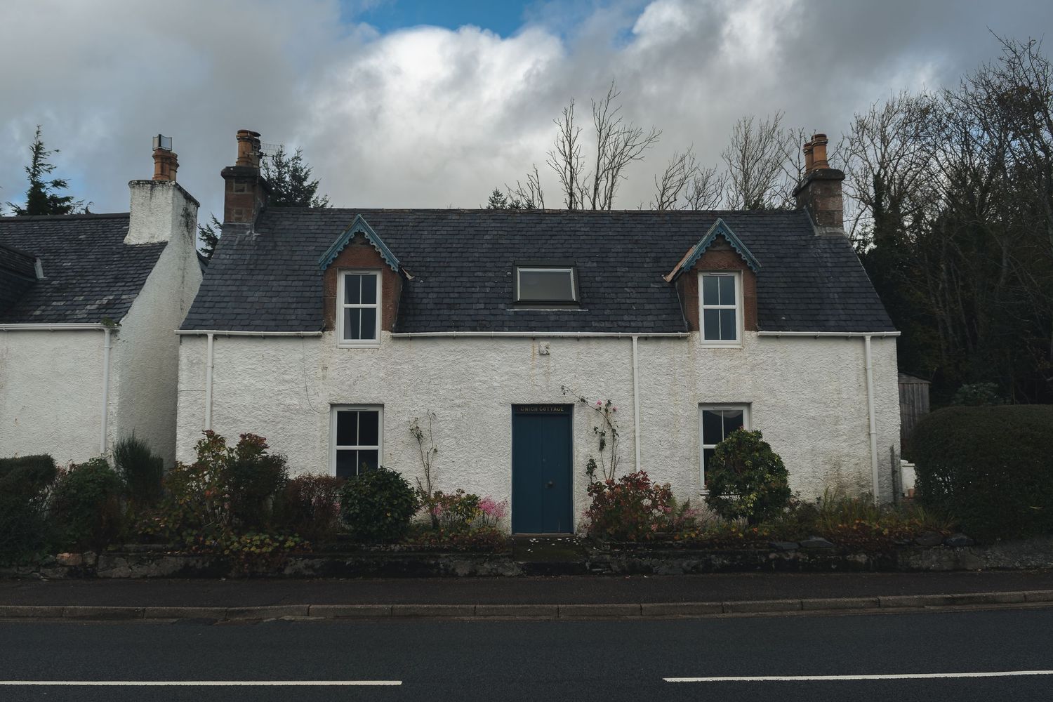 Façade de cottage blanc avec jardin de bordure. Photographe activité plein air et outdoor pour le secteur touristique.