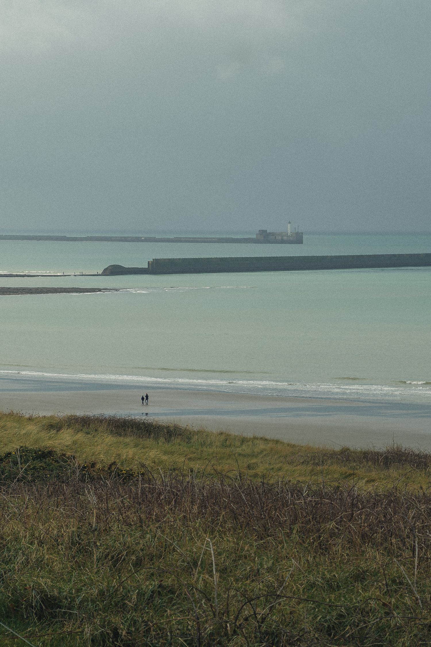 Bâtiment maritime et phare de Boulogne-sur-Mer sous ciel gris.