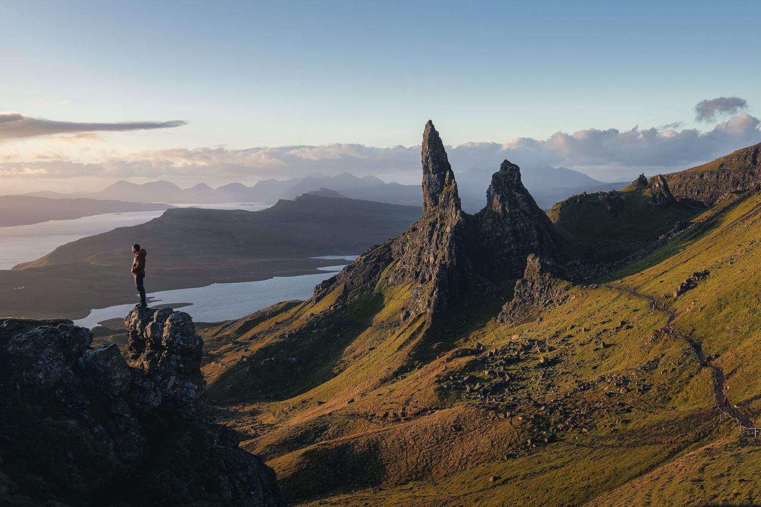 Silhouette contemplant l'Old Man of Storr au lever du soleil sur l'île de Skye. Photo outdoor immersive et destination phare.
