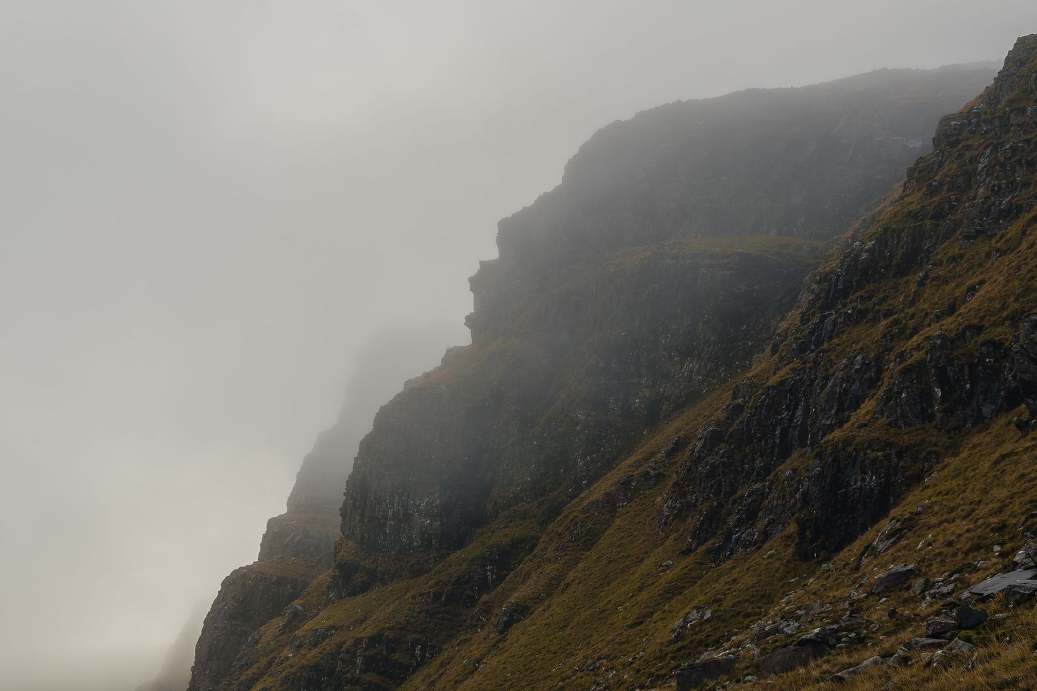 Falaises escarpées des Highlands sous la brume, Écosse. Photo d'art minimaliste et atmosphérique sur la NC500 par un photographe de paysage.