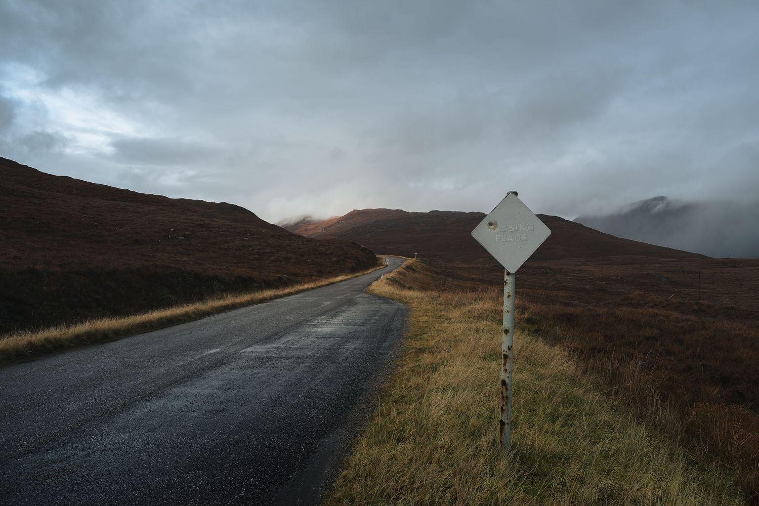 Panneau Passing Place sur une route à voie unique dans les Highlands, symbole d'un road trip authentique en Écosse.