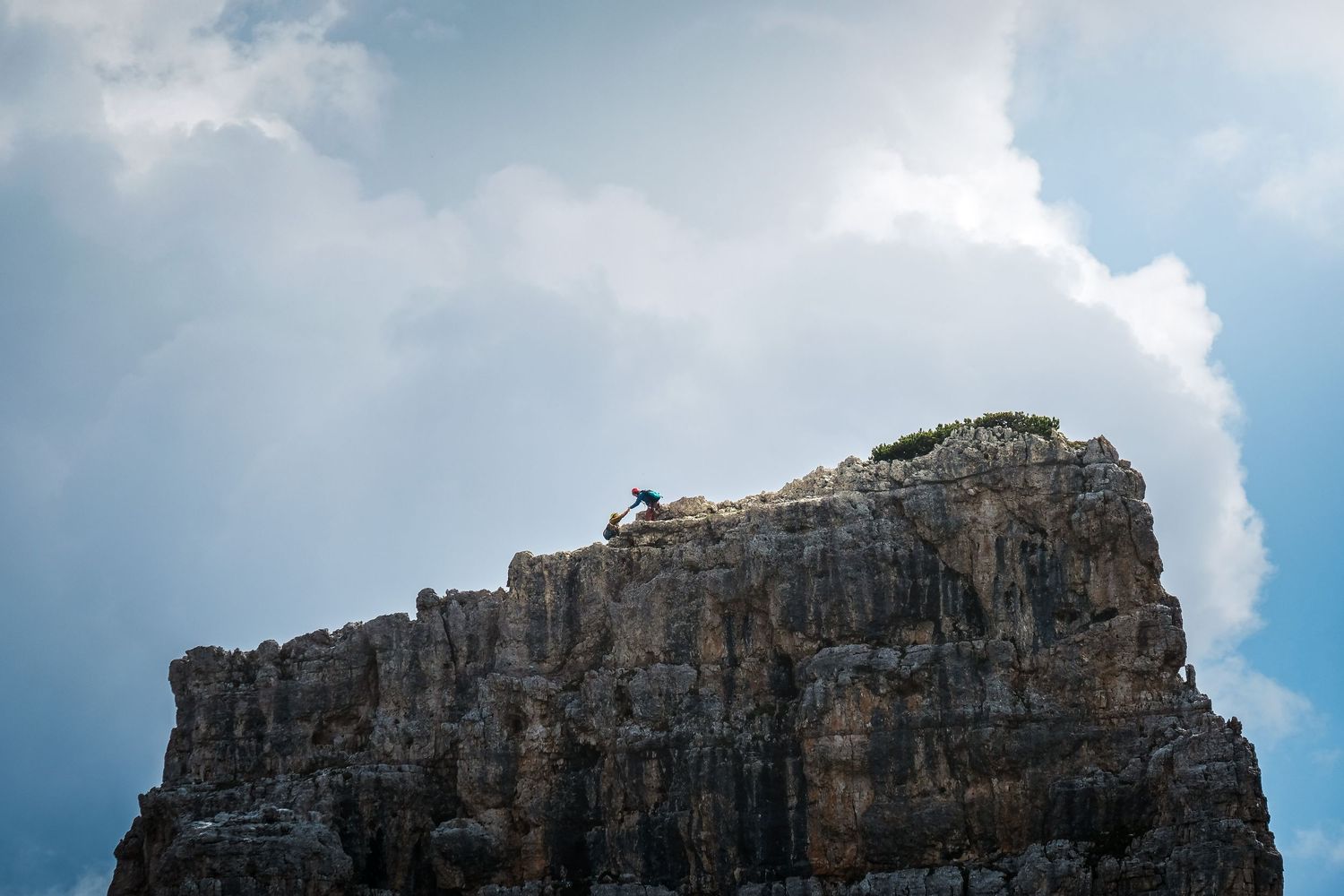 Alpiniste au sommet d'une des Cinque Torri dans les Dolomites, sport d'escalade en haute montagne.