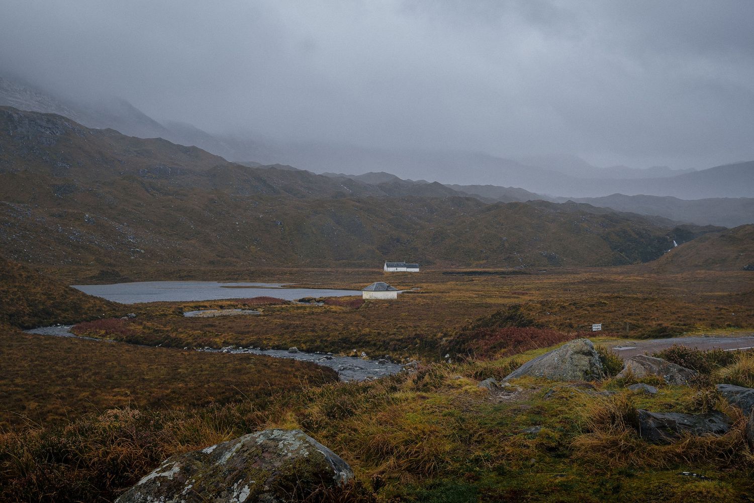 Paysage de lande en Écosse avec un petit loch et deux maisons blanches. Highlands, photographie de tourisme nature et outdoor.