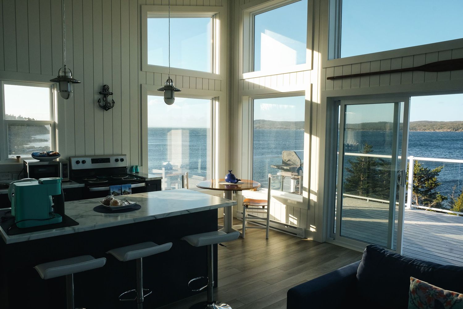 Intérieur lumineux d'un logement typique à Dildo, Terre-Neuve, avec cuisine moderne et vue panoramique sur le bras de mer.