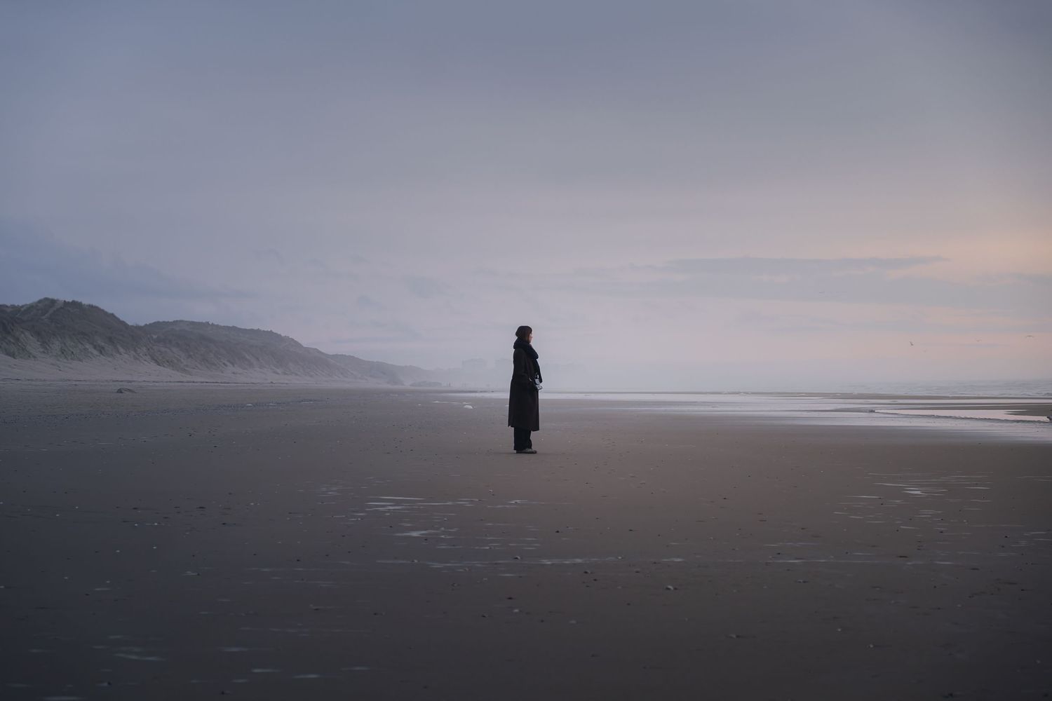 Photographie minimaliste d'une silhouette seule sur une plage brumeuse à Équihen-Plage, reportage photo tourisme et territoires sur la Côte