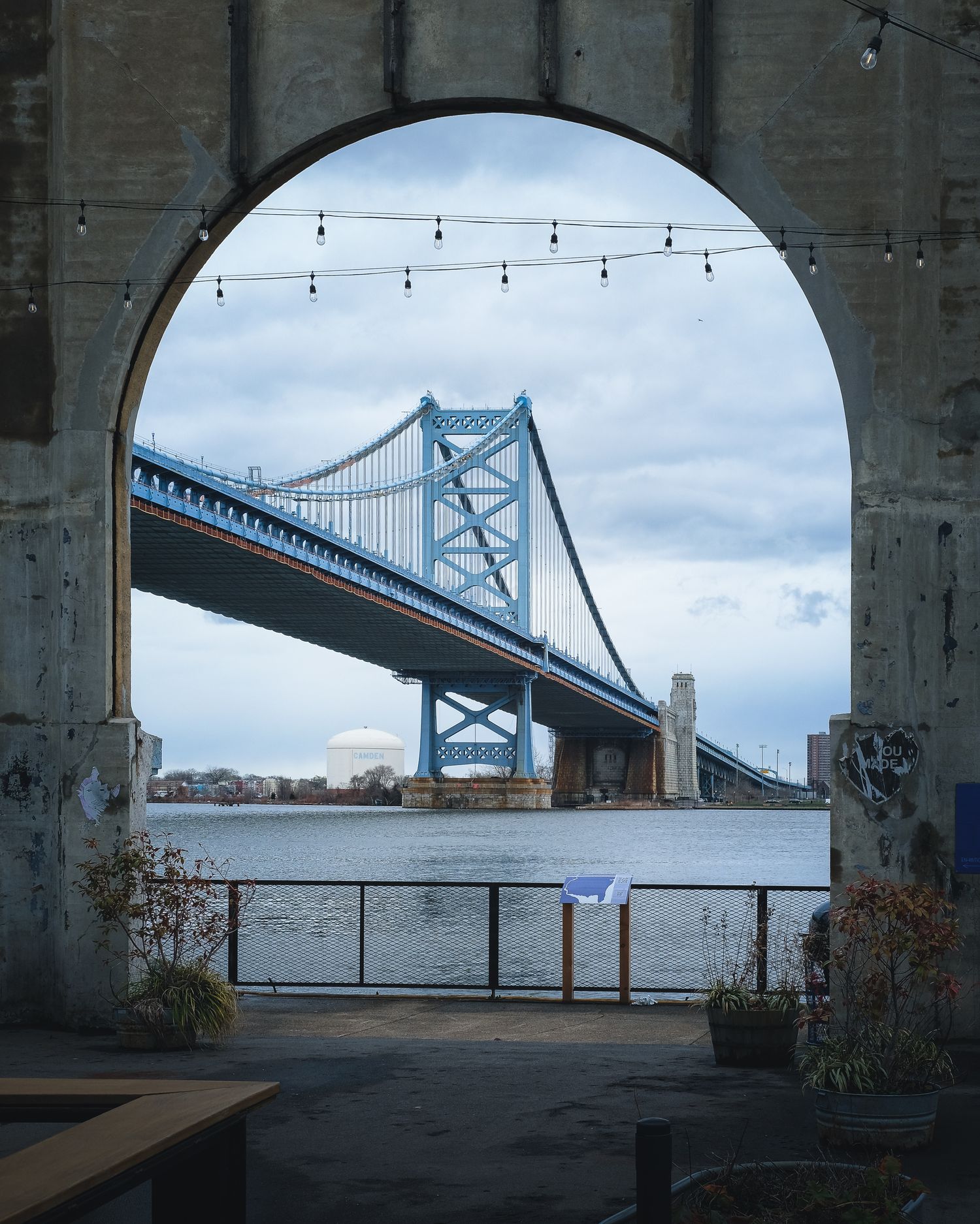 Le pont Benjamin Franklin encadré par une arche en béton sur le front de mer de Philadelphie. Photo d'architecture urbaine et de voyage.