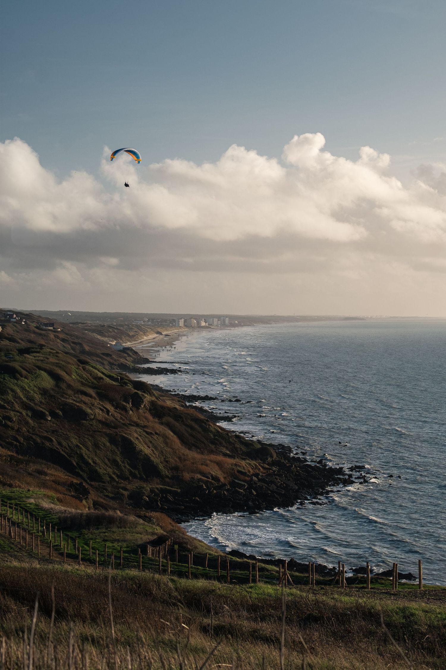 Parapente survolant le littoral et les falaises d'Équihen-Plage.
