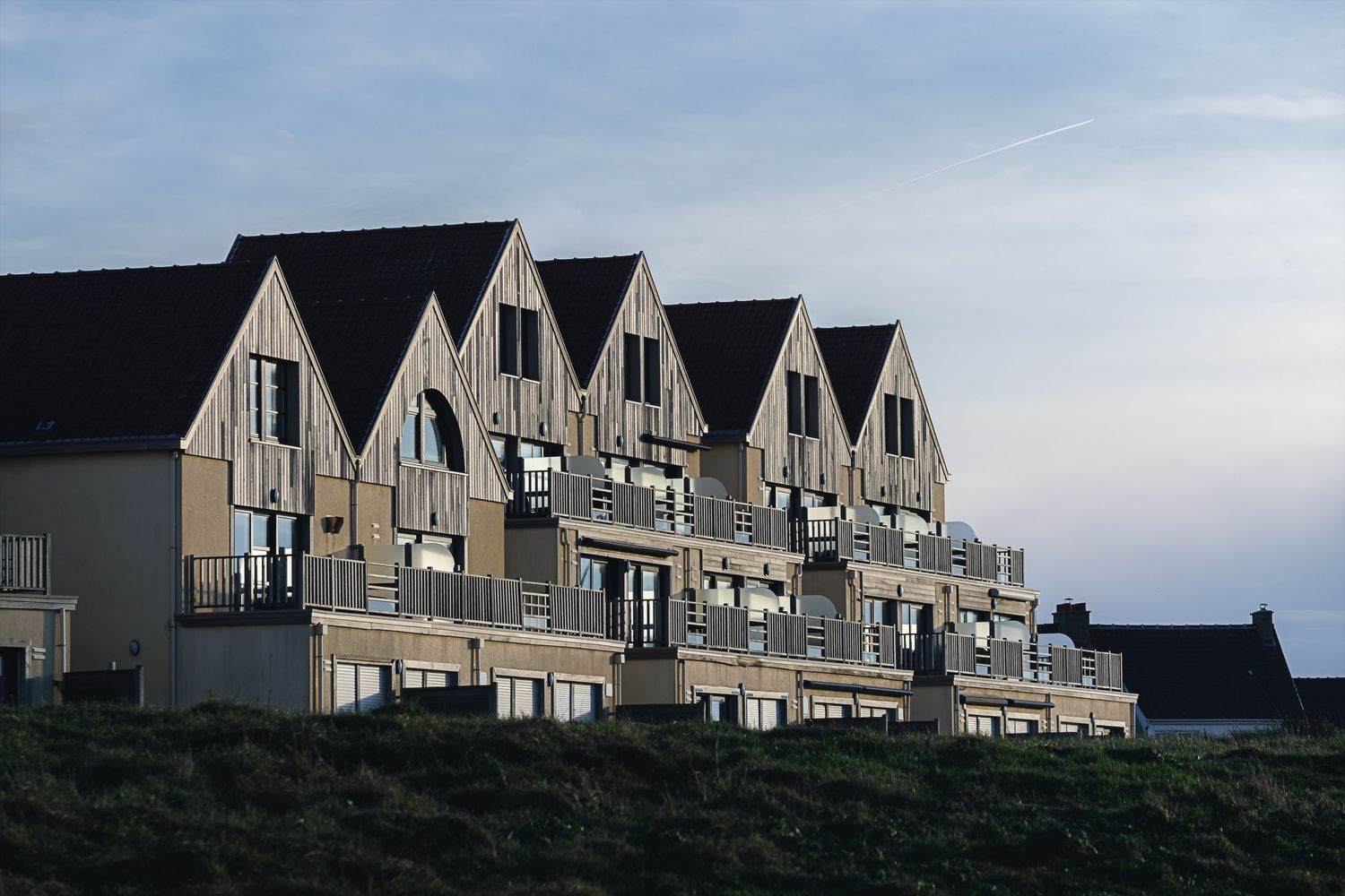 Alignement de résidences modernes à l'architecture de bois et pignons pointus à Wimereux, sur la Côte d'Opale. Photo de patrimoine bâti.