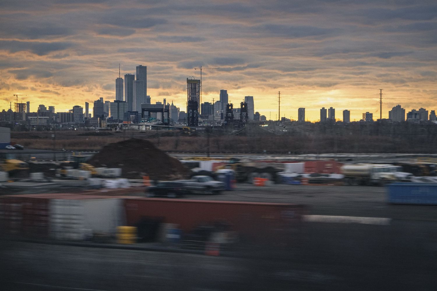 Vue de la skyline de Manhattan et One World Trade Center depuis un train au crépuscule.