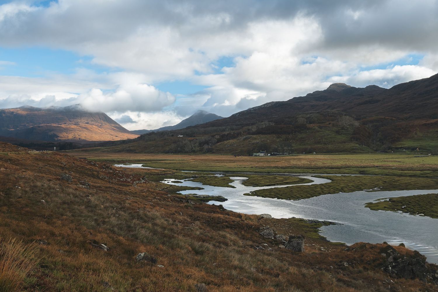 Vallée avec rivière entre deux versants montagneux en Écosse.