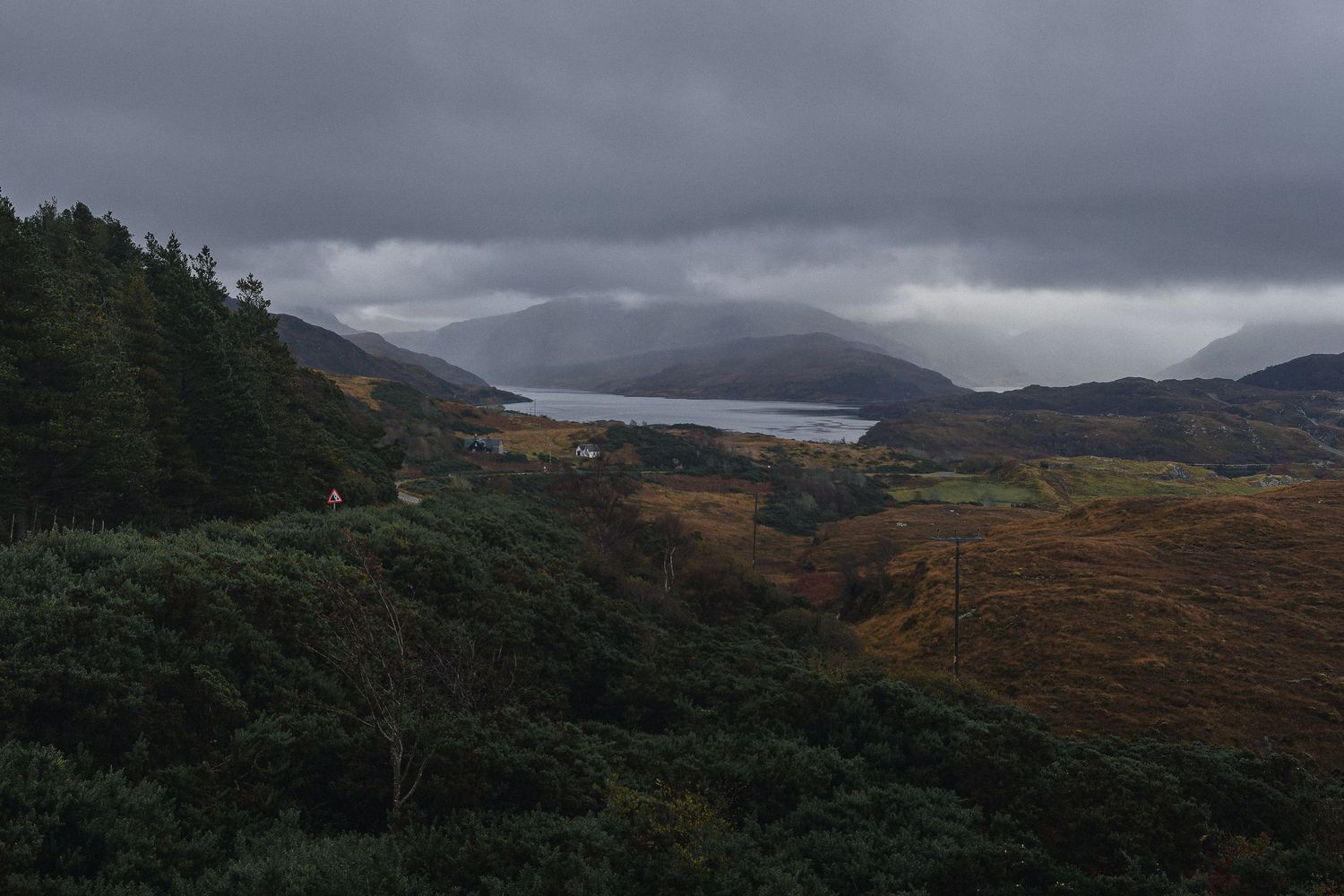 Loch et montagnes des Highlands sous un ciel couvert. Paysage d'Écosse pour photographie outdoor, tourisme nature et hôtellerie de plein air