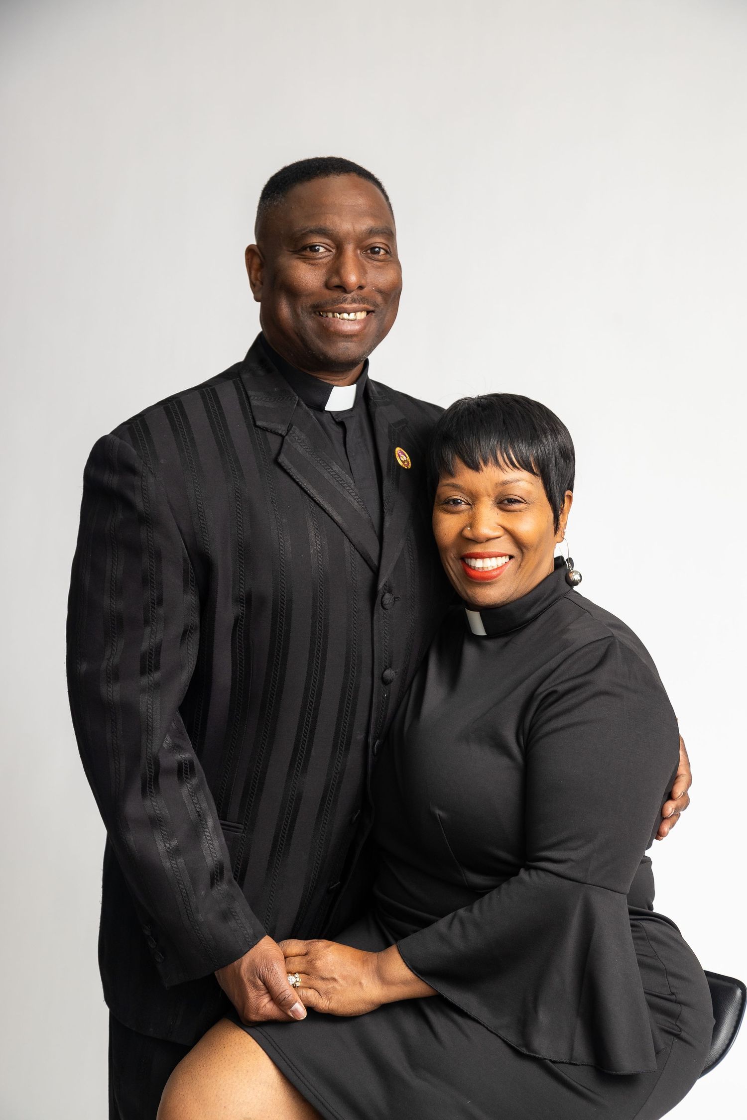 Professional portrait of clergy members in traditional black attire.